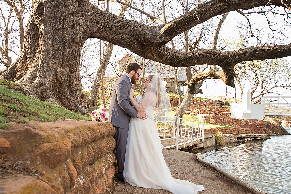 Wedding couple standing by river in Medicine Park, OK.jpg