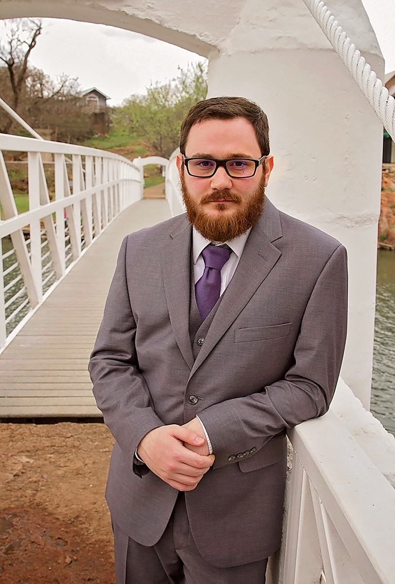 Groom standing by bridge in Medicine Park, OK.jpg