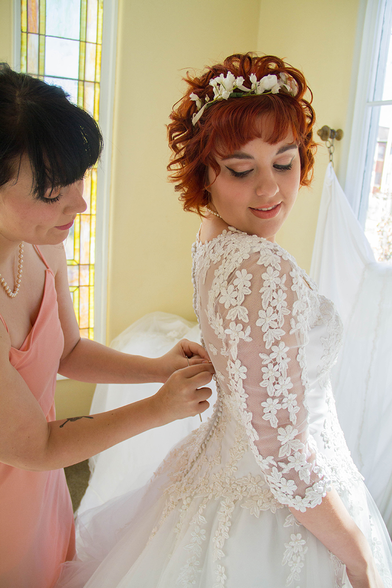 Vintage Bride getting dress buttoned by bridesmaid.jpg