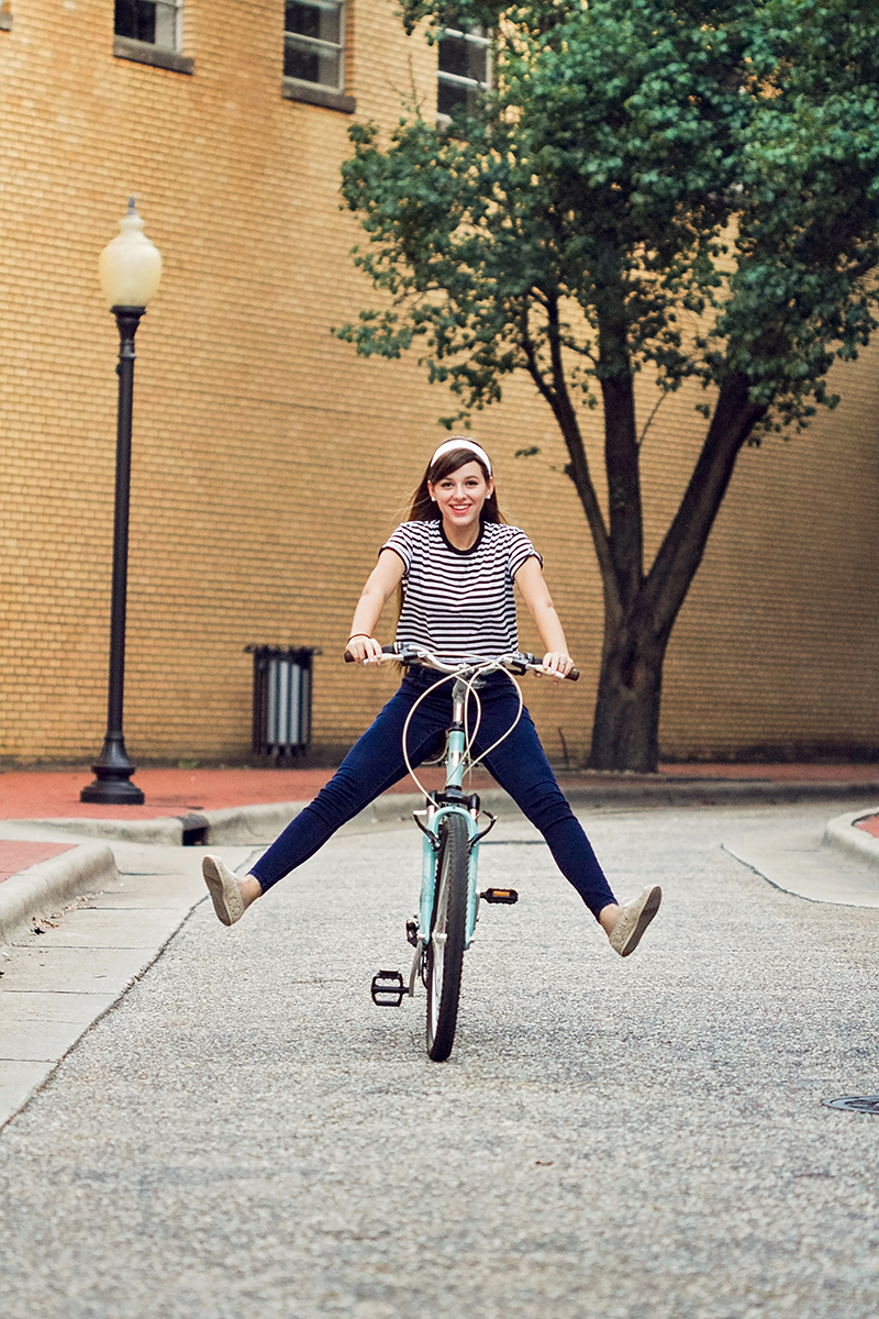 Audrey Hepburn styled session girl riding bike down street.jpg