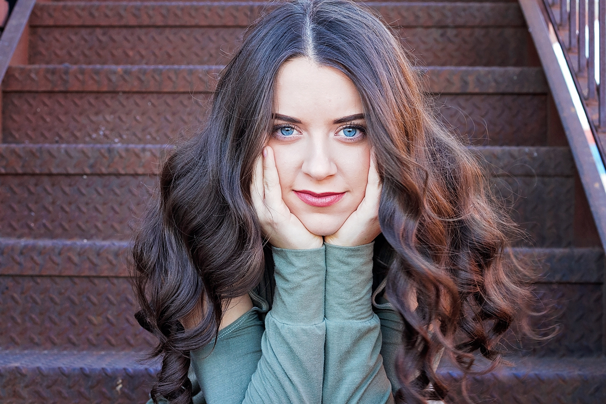 Senior Girl sitting on stairs with bright blue eyes.jpg