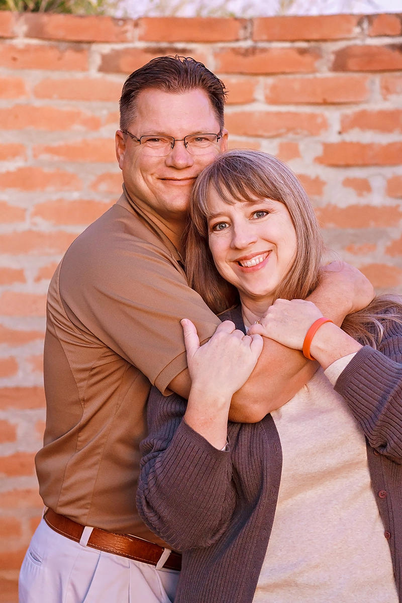 Portrait of Couple in Tan and Gray hugging.jpg