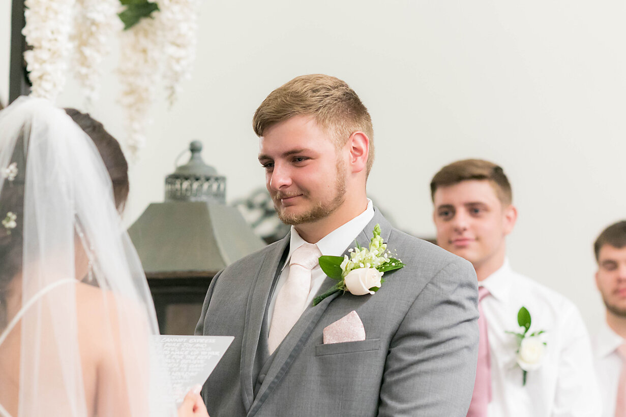 Groom looking at bride reading vows-ceremony- parsons wedding- rose briar place- oklahoma city weddings.jpg