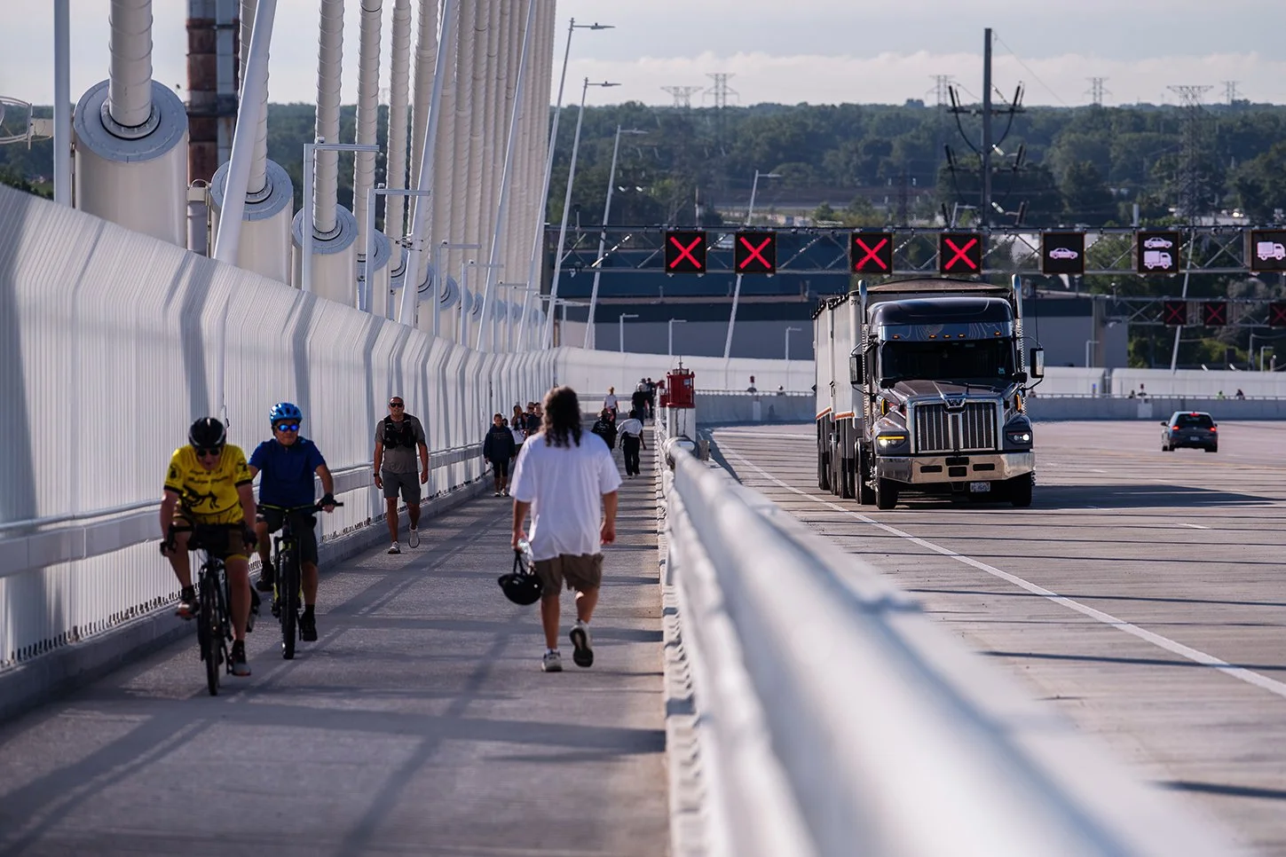 People walking across the international border between Detroit and Windsor on the Gordie Howe International Bridge.