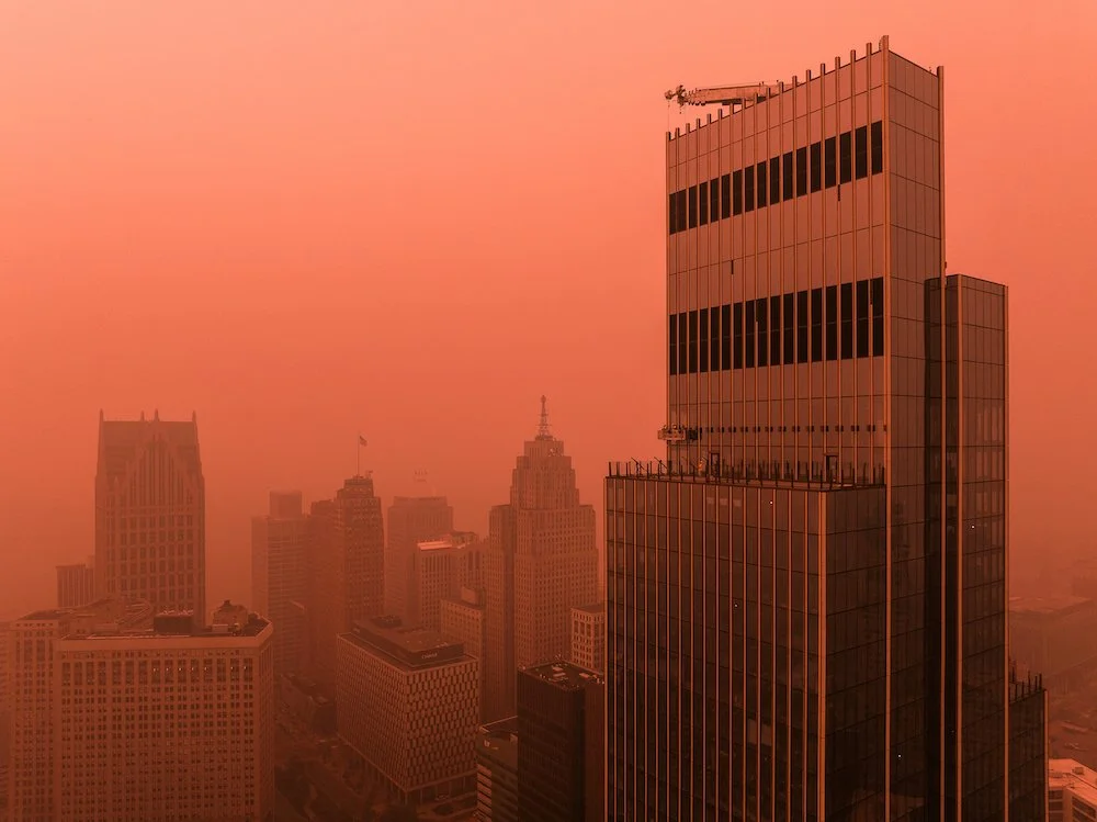 Architectural drone photograph of downtown Detroit showing the skyline during summer wildfire smoke conditions.