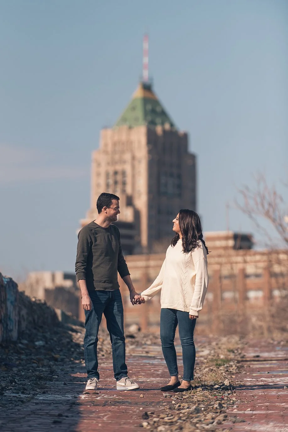   Couple embracing in an urban Detroit setting, photographed by a Detroit wedding photographer.  