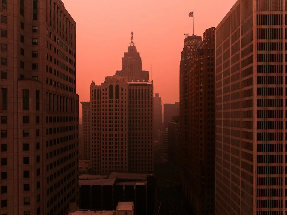 Drone photograph overlooking downtown Detroit, capturing the city's skyline and architecture during smoky summer conditions.