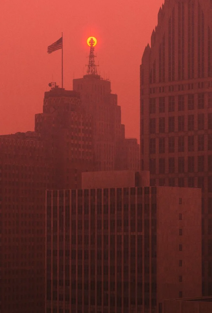 Aerial architectural view of downtown Detroit showing muted light and haze from regional wildfire smoke.