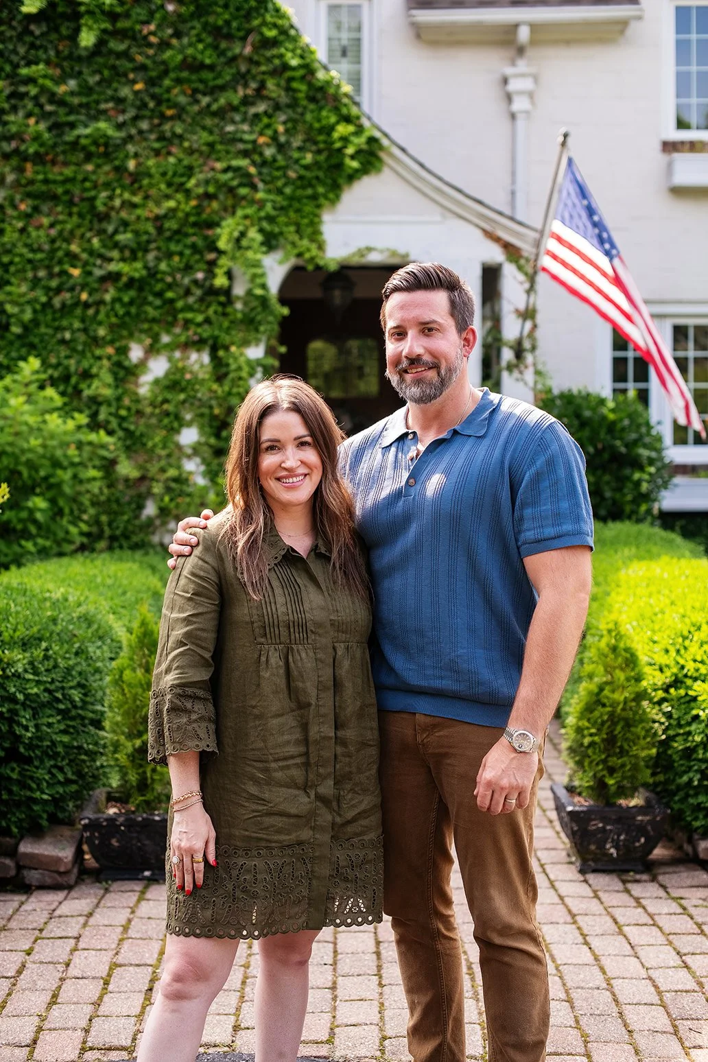 An owner’s portrait taken outside a historic Michigan Tudor home, capturing the personal connection and lived-in story behind The Gratz Life.