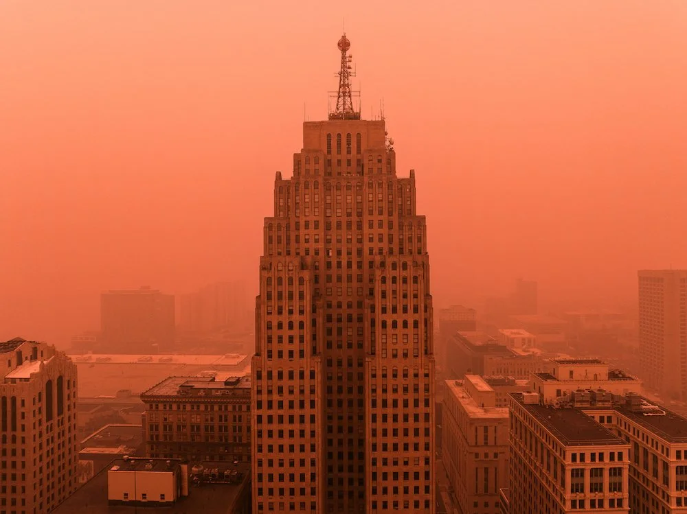 Drone photograph documenting the buildings and skyline of downtown Detroit during smoky summer conditions.