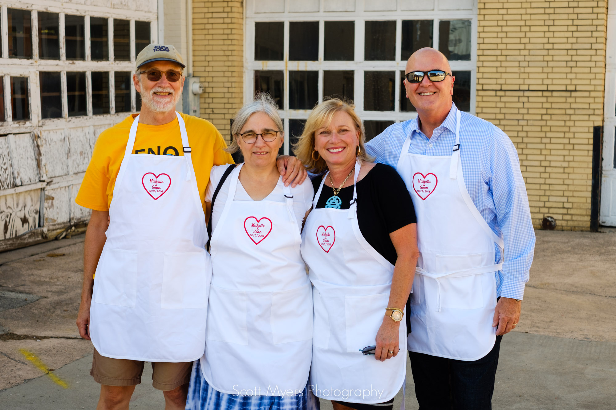 Parents, in their serving aprons for the rehearsal dinner