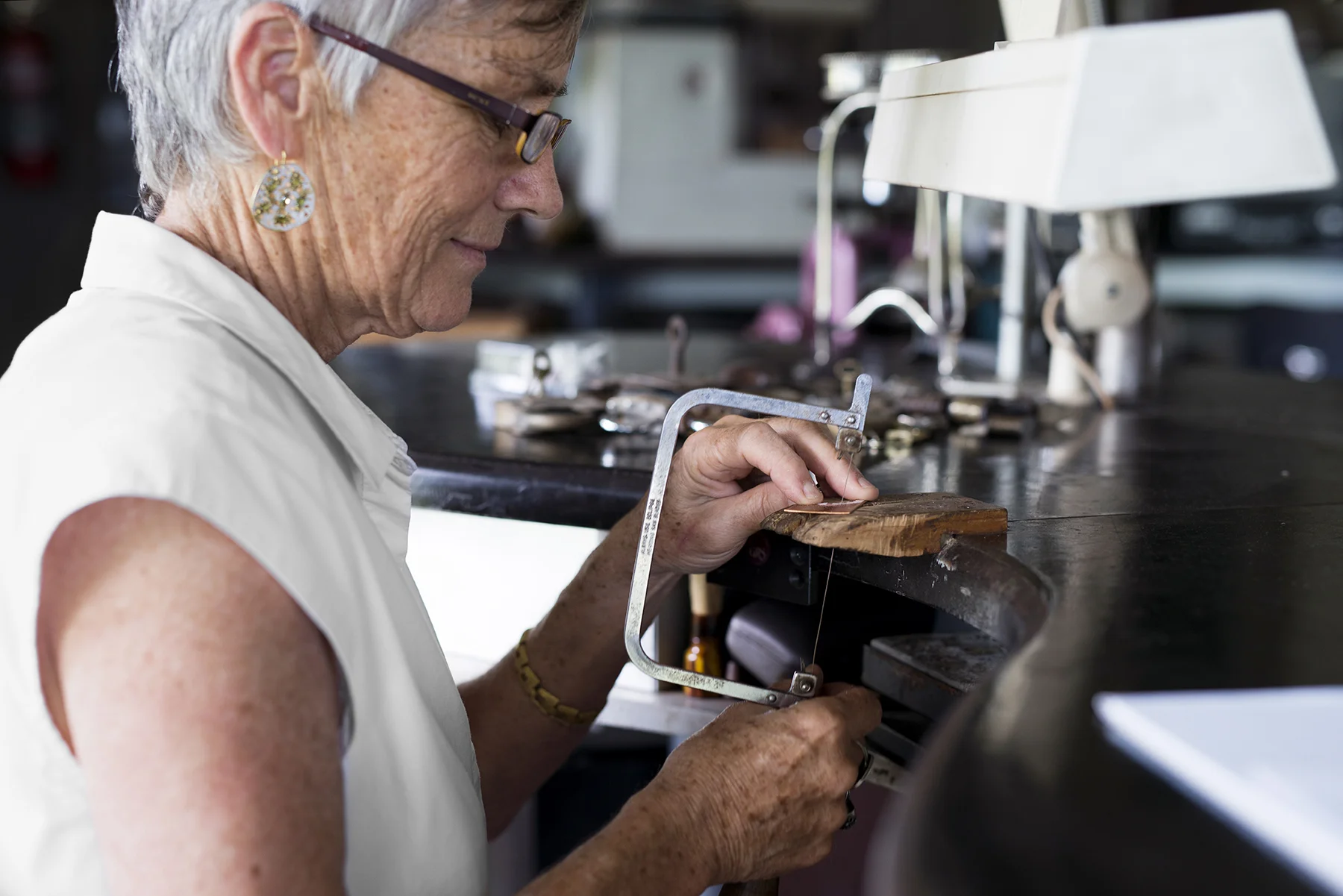 Barb saws out a Banksia leaf shape from a sheet of metal.