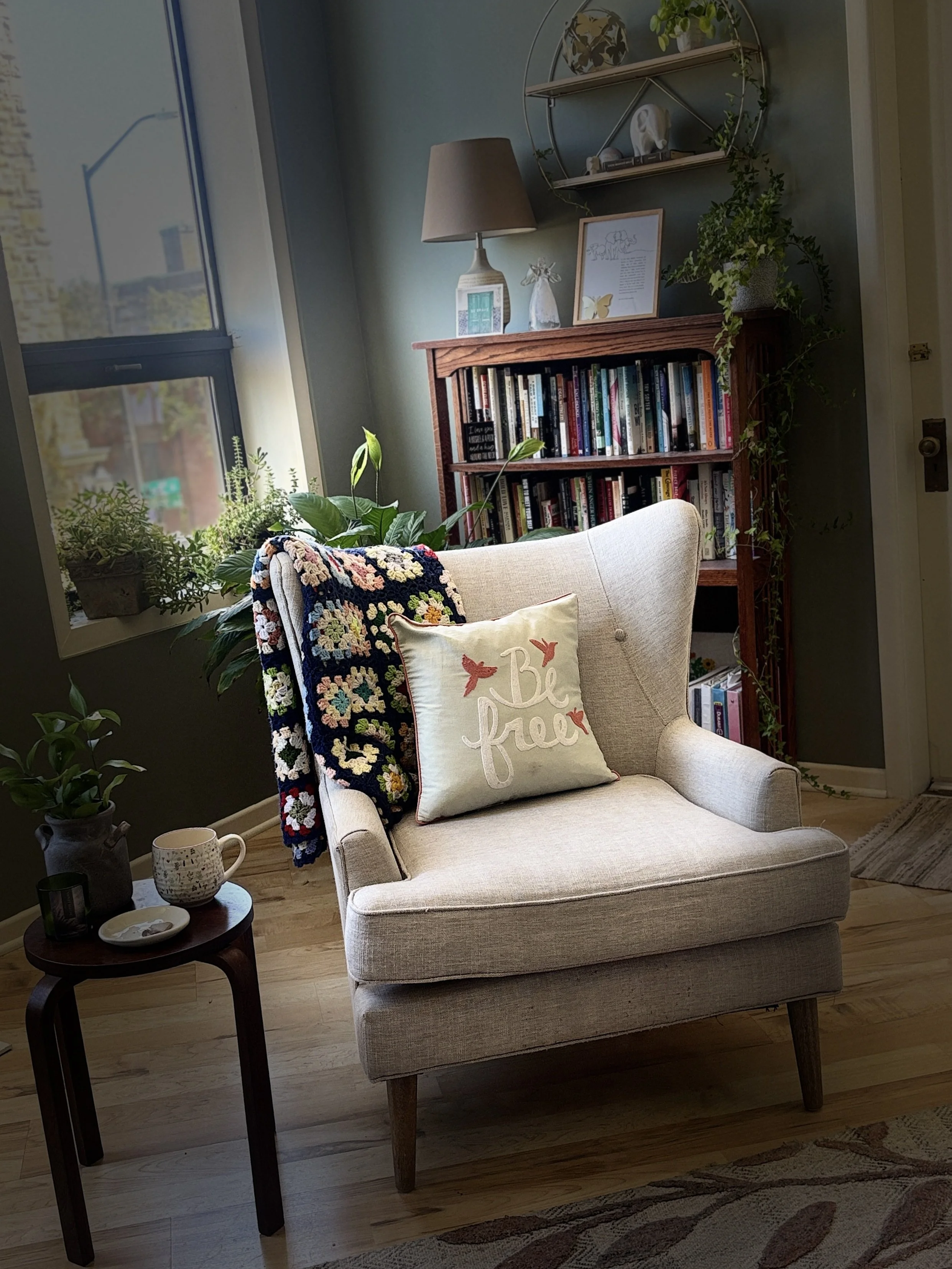 An armchair with cozy accessories in a therapy office space
