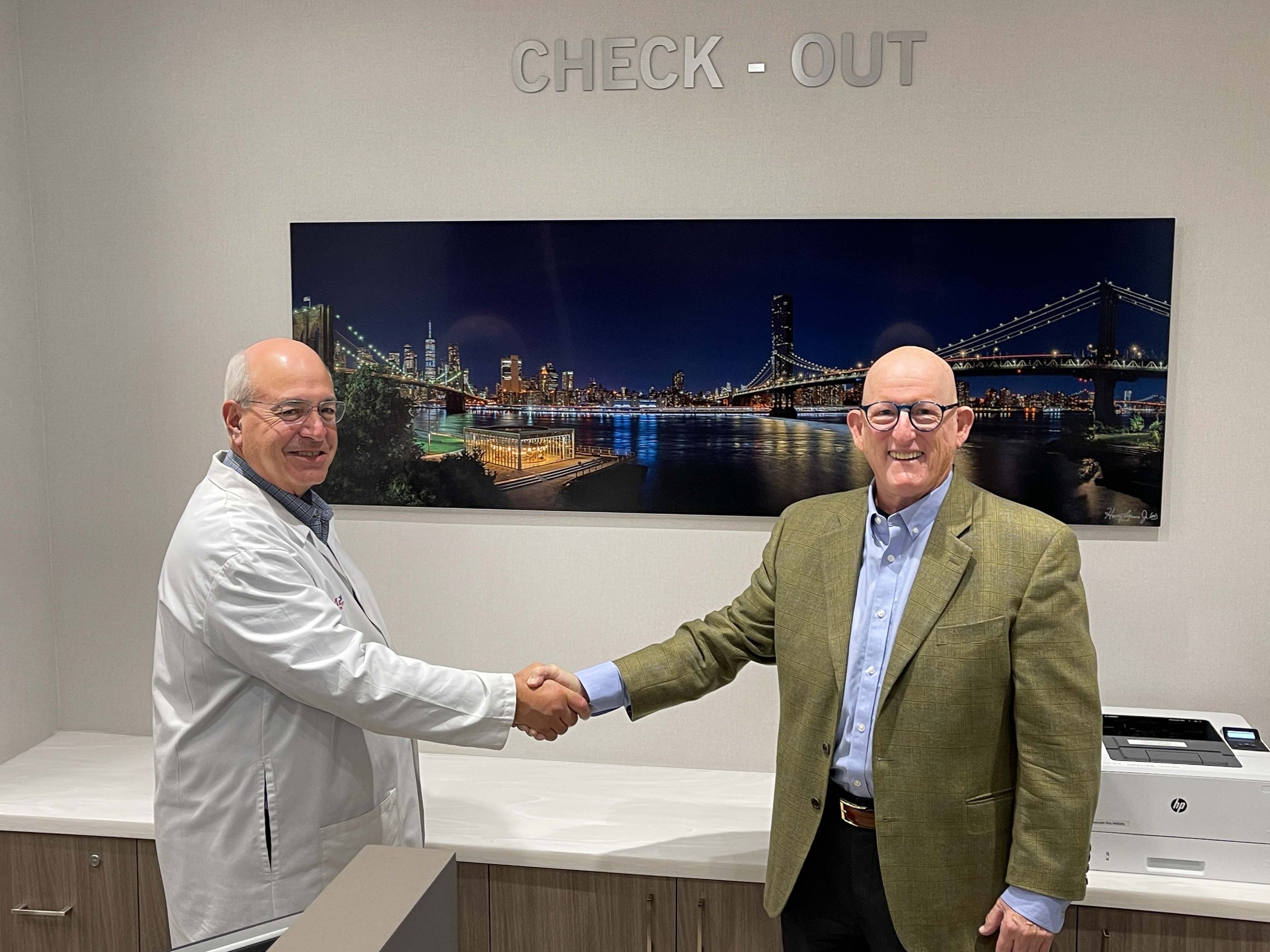 Neil Cobelli, MD,  Chair, Department of Orthopedic Surgery and Dr. Agress with newly donated print of the Brooklyn and Manhattan Bridges with "Jane's Carousel"