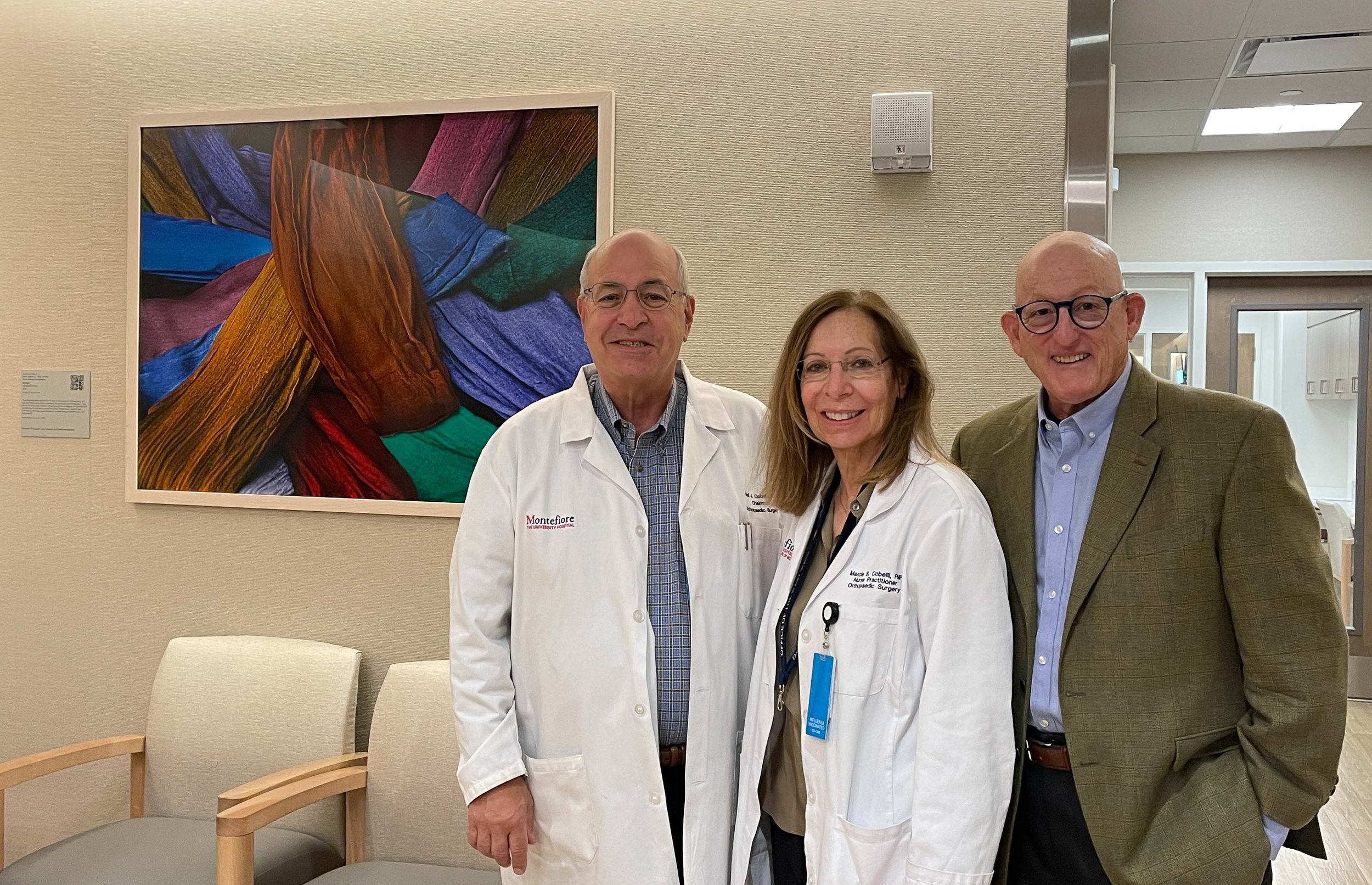 Neil Cobelli, MD,  Chair, Department of Orthopedic Surgery, Marcie Cobelli, NP, Administrative Director and Dr. Agress with donated print, "Scarves. Marrakesh, Morocco"