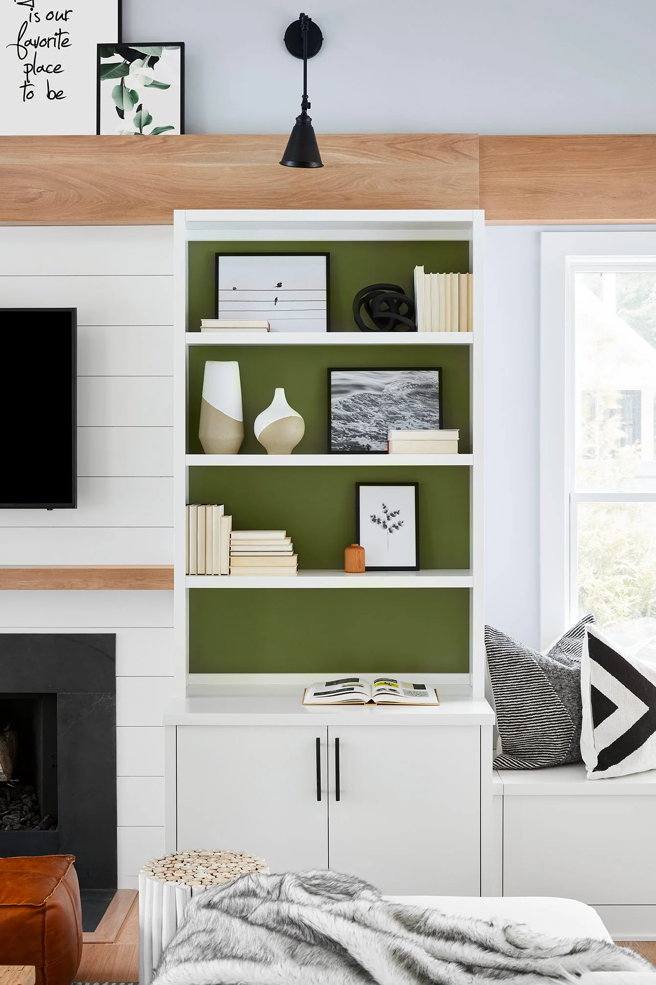 We styled the shelves with backwards, neutral books to add some texture and carried in black and white artwork for contrast. Sculptural pieces and textured vases complete the look. Sconces above the shelves highlight the built-ins and create a warm, inviting glow.