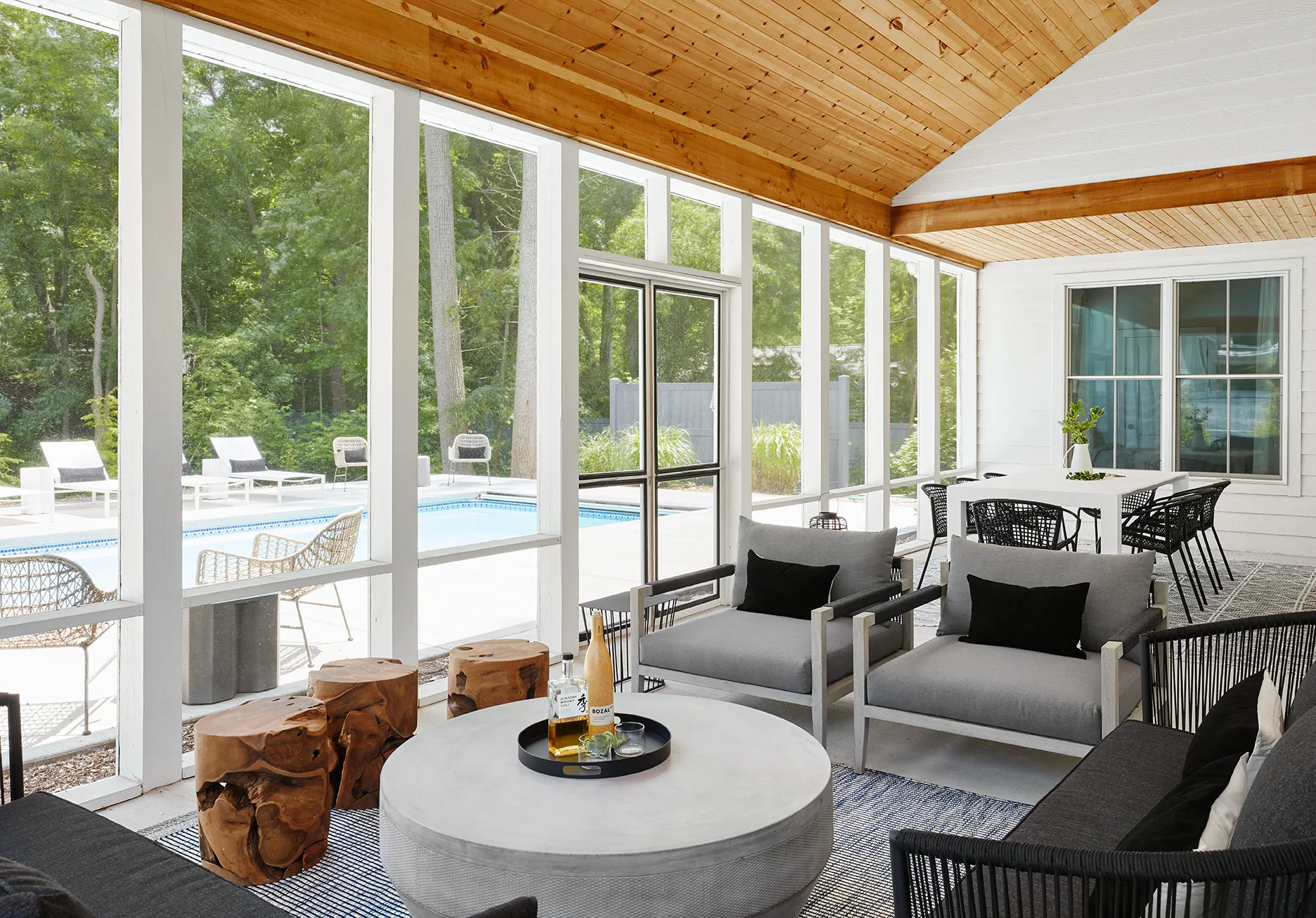 The lounge area on one side provides plenty of space for cocktails once the sun goes down. On the opposite side, a white dining table and black woven chairs complete the area for entertaining.