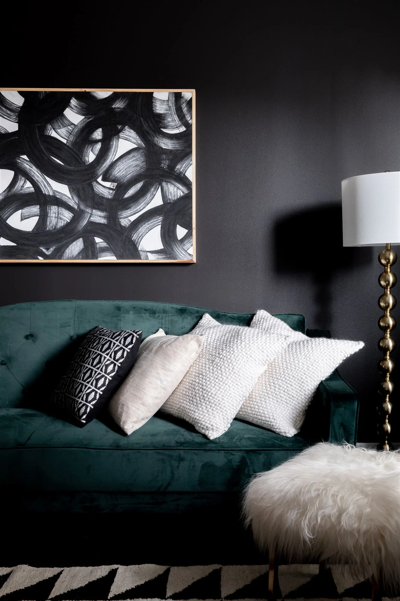 In the office, we carried in one last black wall with a luxe, green velvet sofa in front of it. The rug in here pulls in a black and white geometric pattern to create a cohesive feel with the rest of the house.