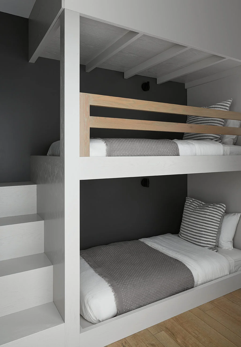 Custom bunkbeds provide cozy nooks for kids to curl up in, complete with reading lights and a staircase in lieu of a ladder (and if anyone else has had to make up a top bunk, you can appreciate why we went with this option).