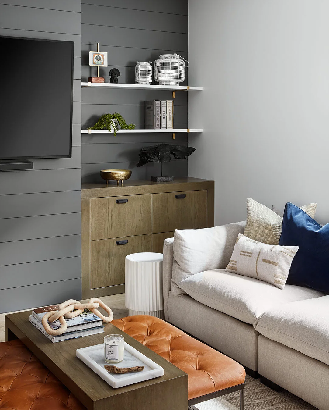 The L-shaped sectional provides a deep, inviting space for friends and family to curl up in during a movie. Instead of a coffee table, we opted for a soft, tufted ottoman and created a custom waterfall table to match the built-ins. The table can be …