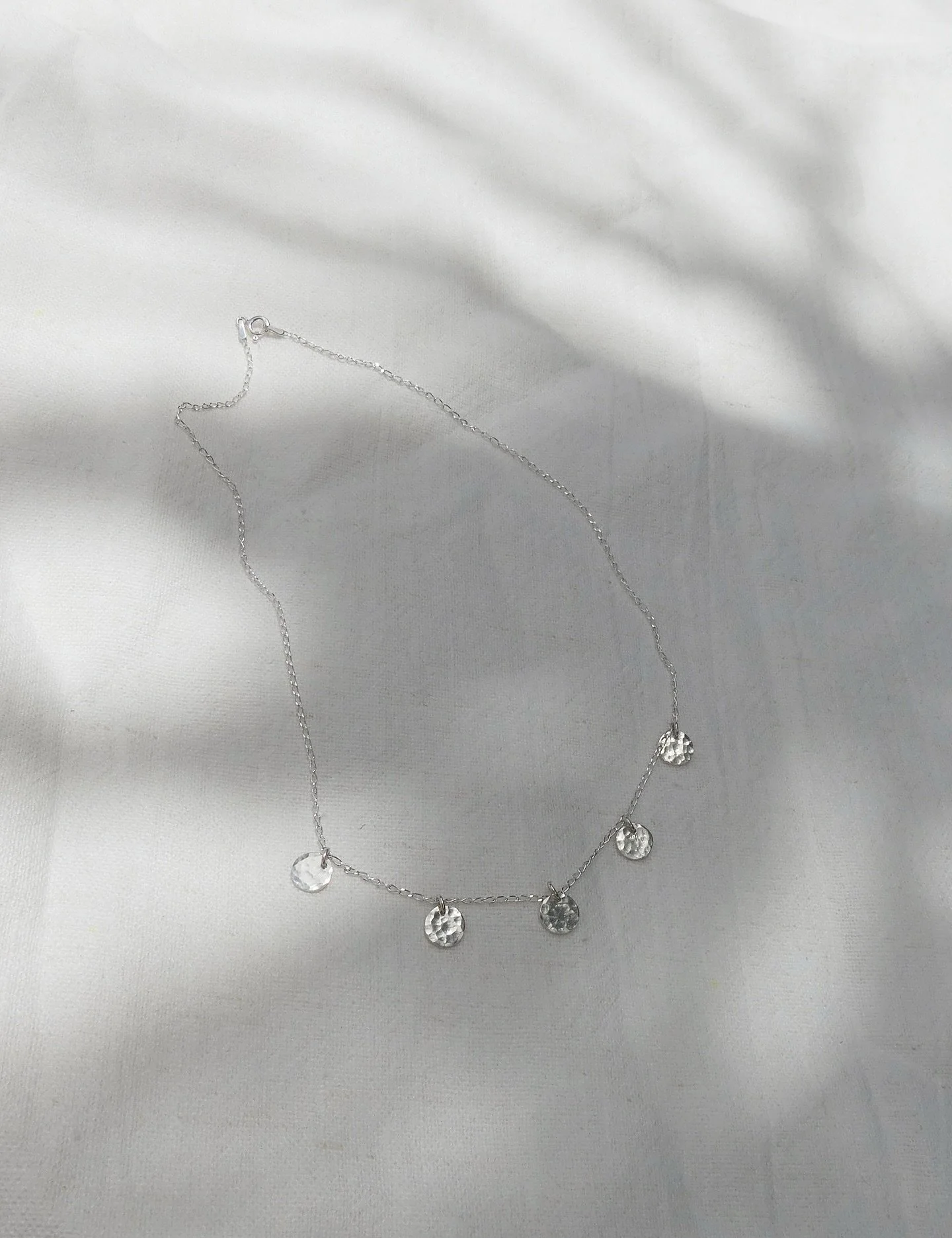 Summer Rain Necklace.
Our favourite collarbone necklace.
5 handmade recycled Sterling Silver discs, with a beautiful hammer texture, reflecting the light like raindrops dancing on the ocean.
Perfect on its own, or layered with another longer pendant 