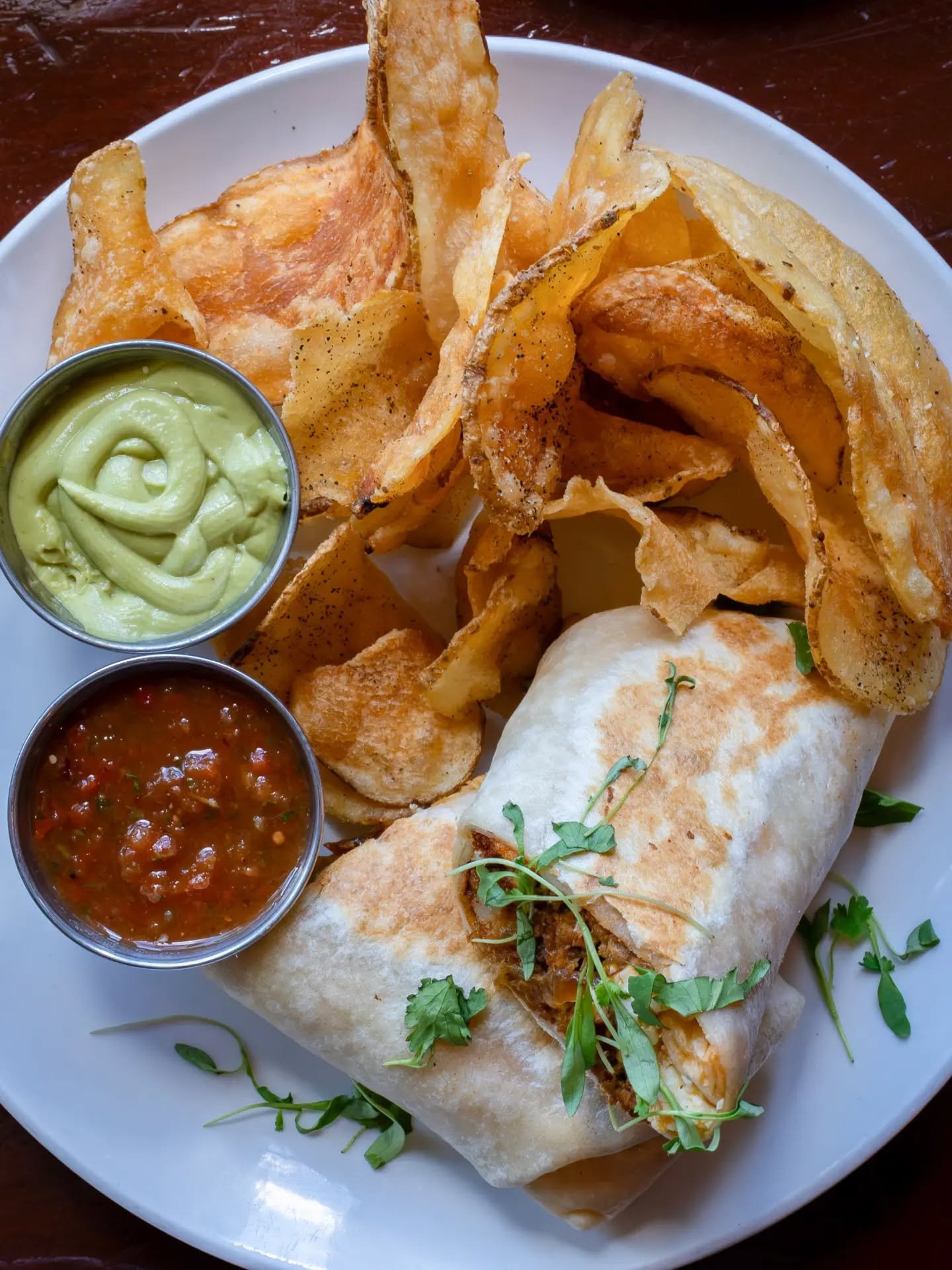 Our Breakfast Burrito doesn't mess around. 🌯

Chorizo, scrambled eggs, seasoned hash browns, caramelized onions, cotija, and cilantro, all wrapped up in a flour tortilla with avocado cream and house salsa. Your choice of chips, fruit, or salad on th