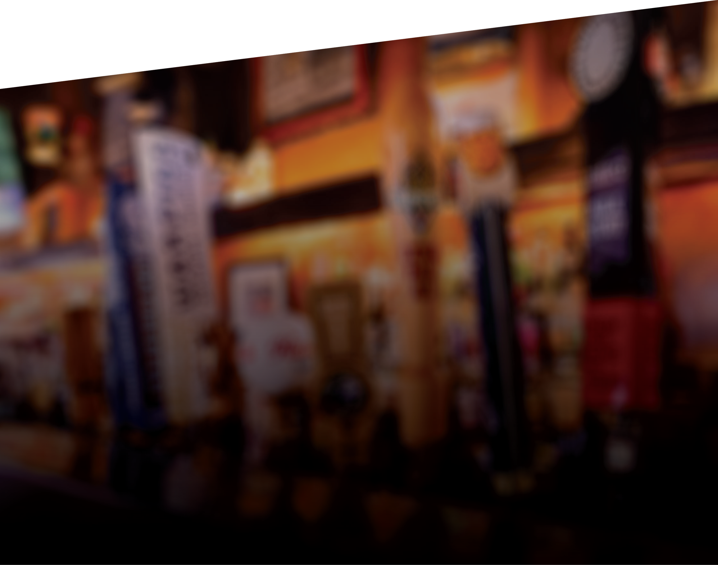 Blurred view of a bar or restaurant interior with warm lighting, menu, and various decorative items on the wall.