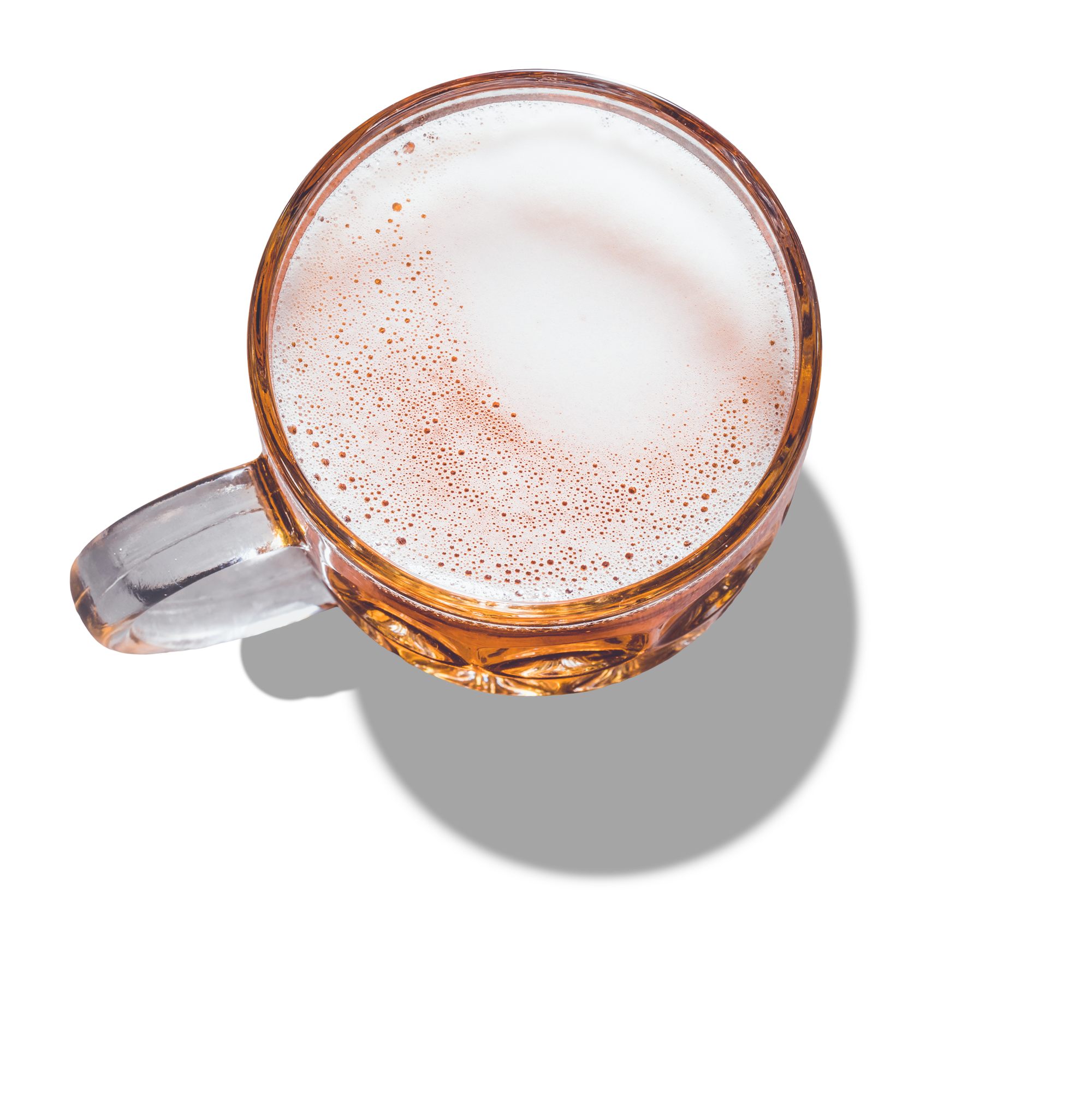 A clear glass mug filled with a frothy, foamy drink, viewed from above.