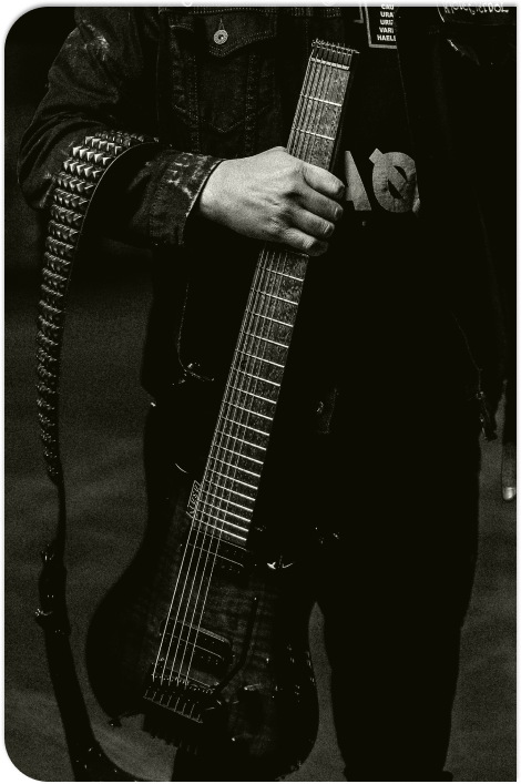 A picture of Drew holding the neck of his guitar