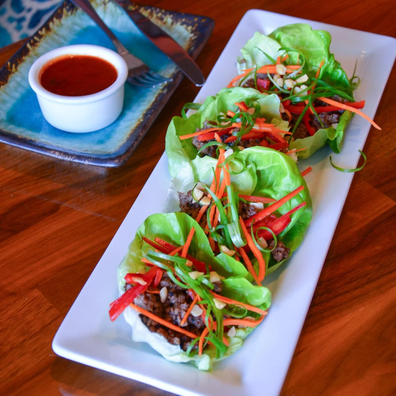 Asian Lettuce Cups, made with green onion, carrot, bell pepper, macadamia nuts, Korean chili sauce - choice of grilled Korean beef, chicken, or tofu. #parkcityfood #parkcityrestaurants