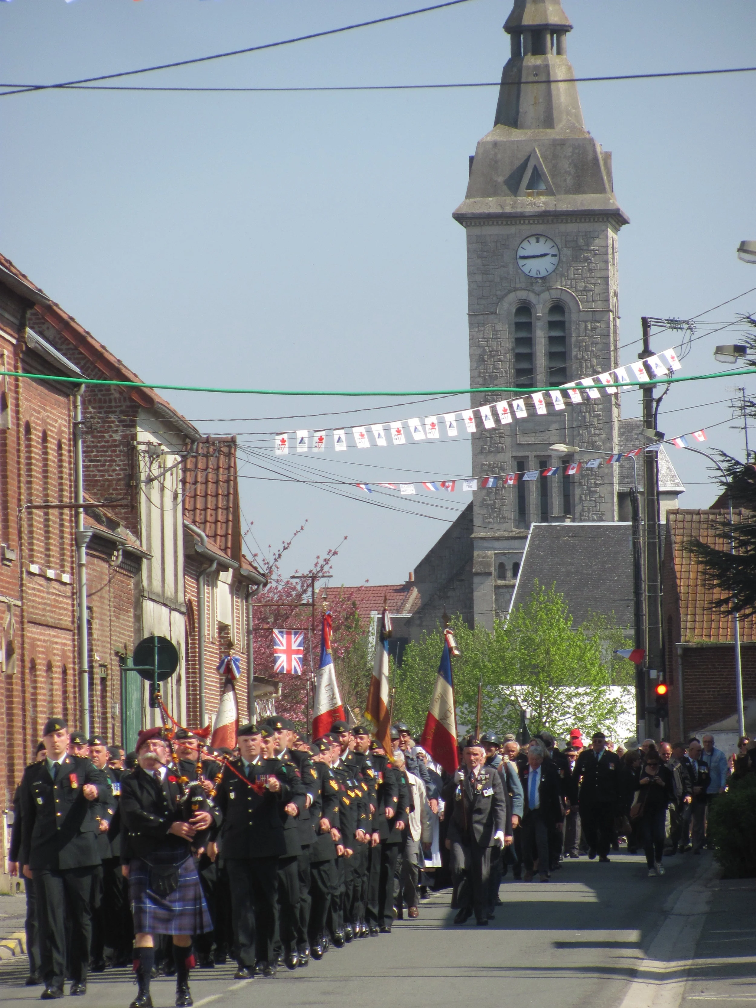 Colin Norris leads the parade of gunners along Rue des Artilleurs, Thelus.