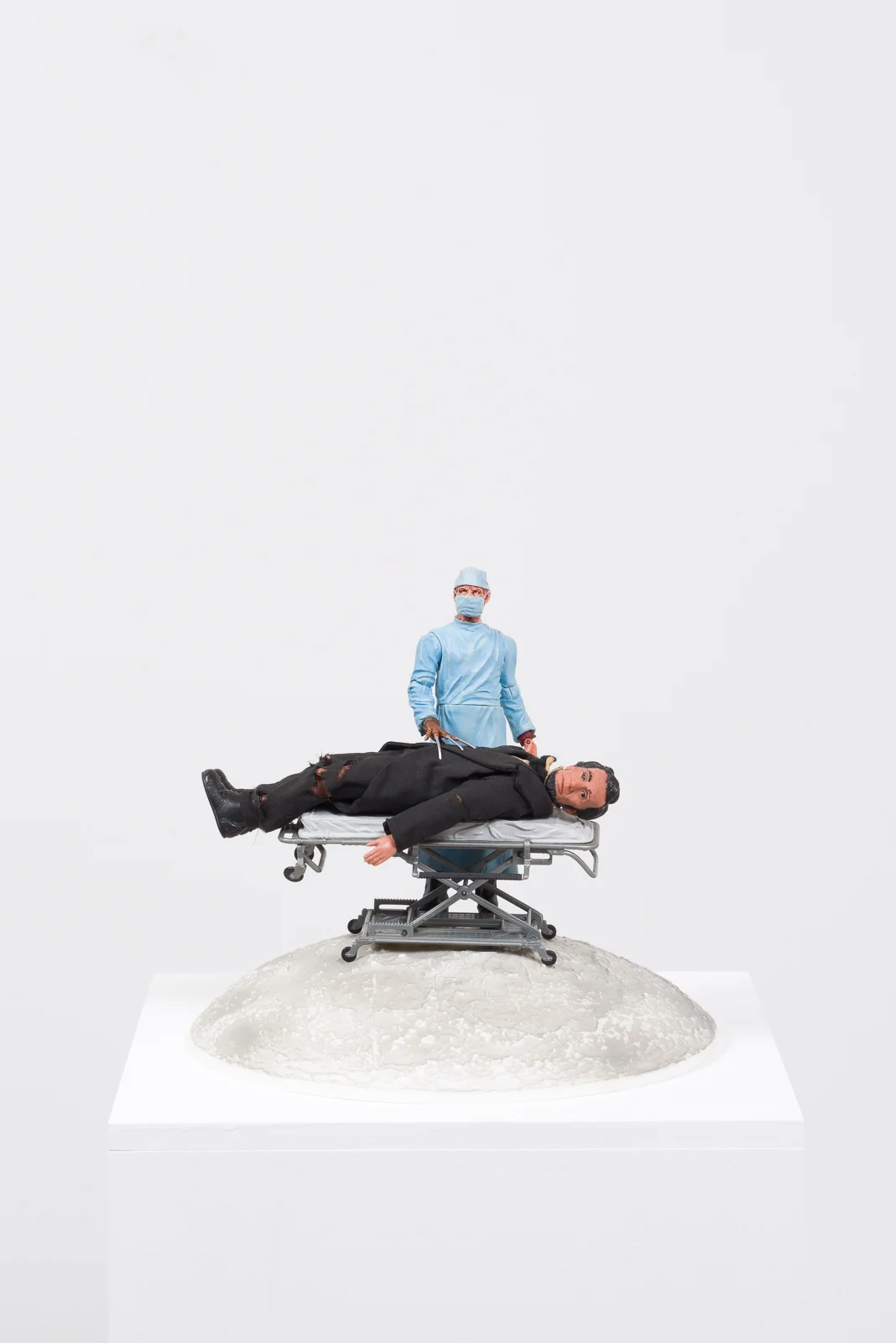Healthcare Cuts, 2017 Plastic moon model, plastic hospital gurney, plastic and vinyl action figures, pedestal