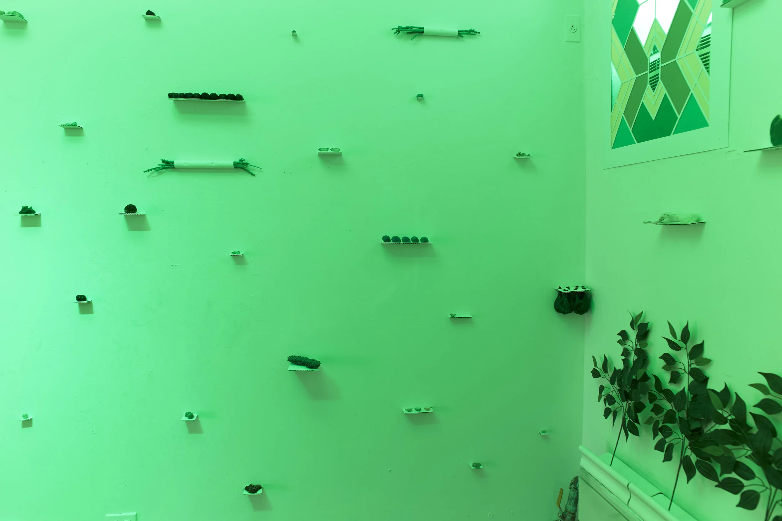  Over 100 green cast objects were installed on all four walls of the studio creating an immersive, temple-like space 