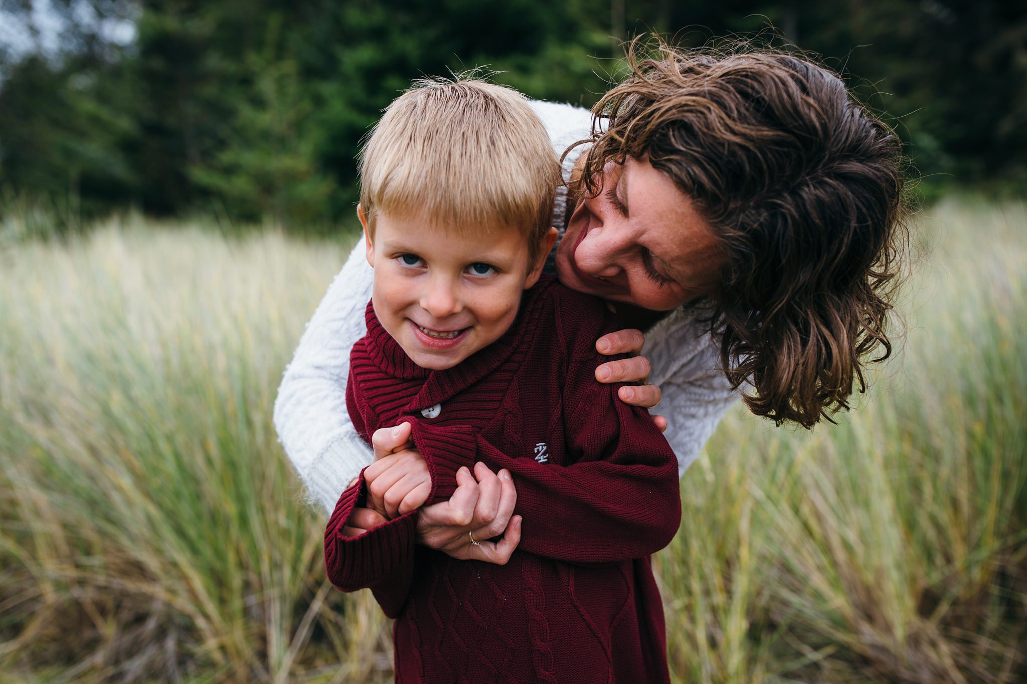 kara chappell whidbey island family photography mom hugs son and whispers in his ear