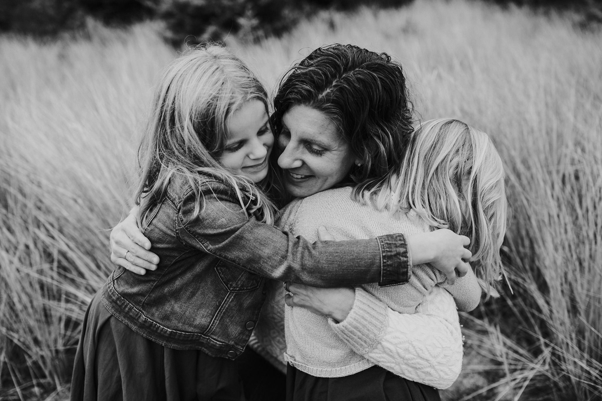 kara chappell whidbey island family photography mom snuggles daughters in field