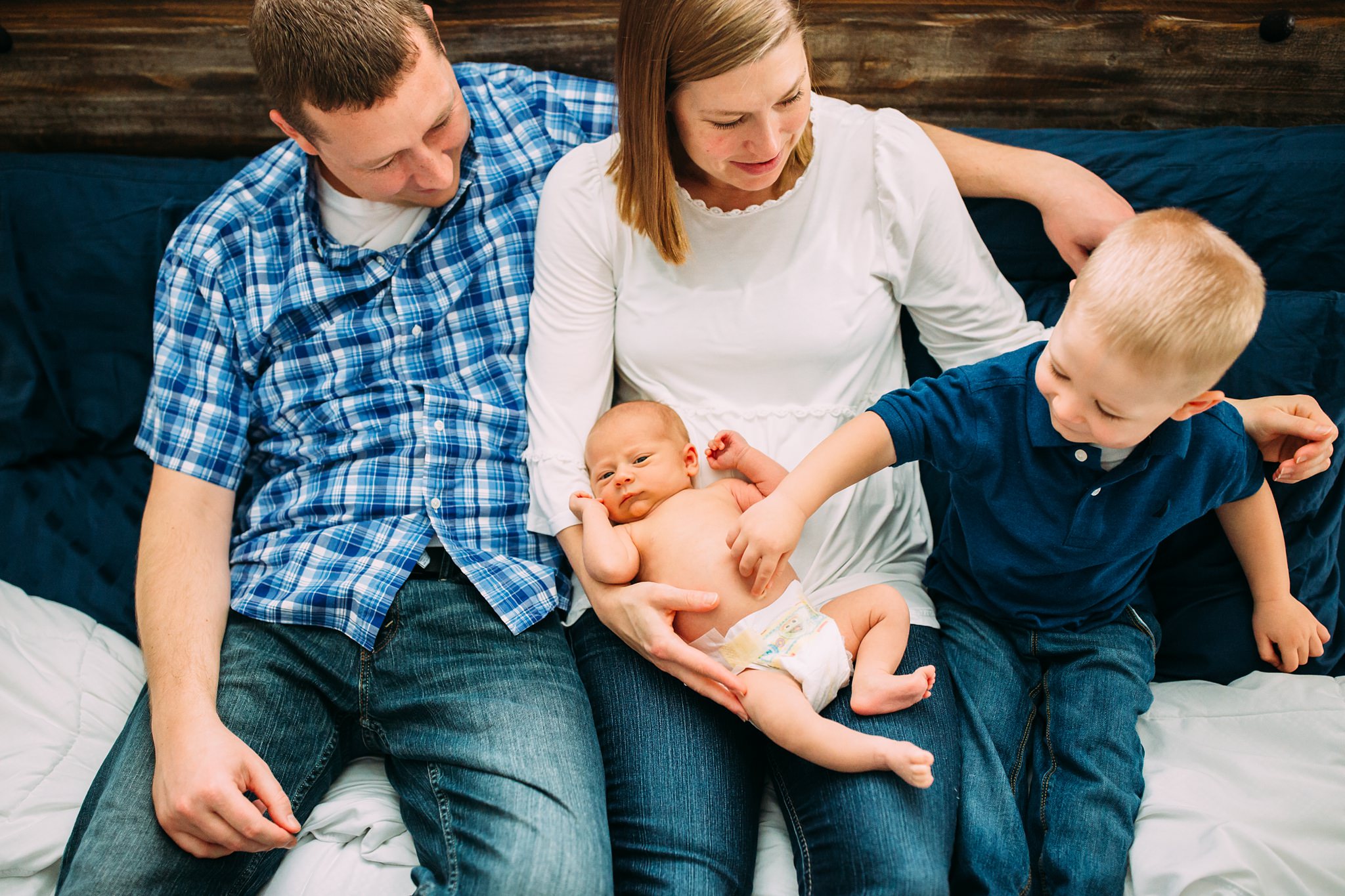 Beautiful Family Snuggles Baby on Bed | Whidbey Island Newborn Lifestyle Photographer