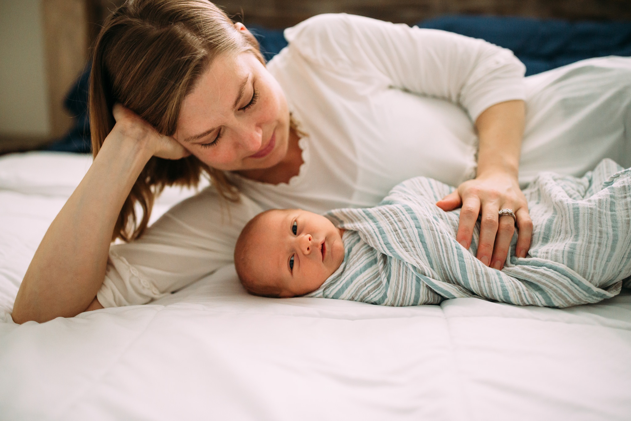 Beautiful Family Snuggles Baby on Bed | Whidbey Island Newborn Lifestyle Photographer