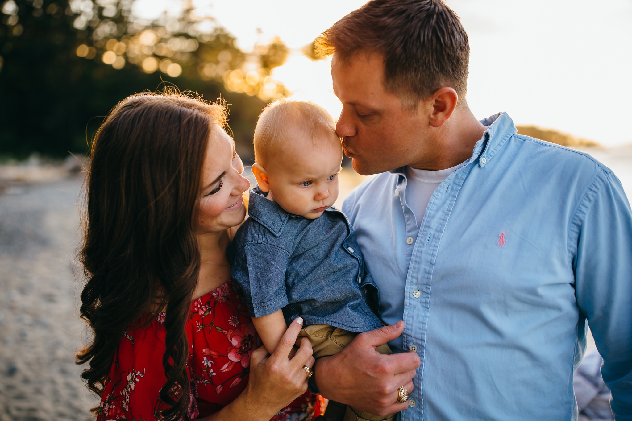 Parents kiss baby on cheek at Deception Pass