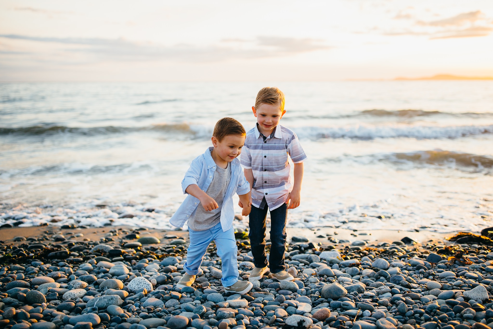 Boys run from surf at Deception Pass