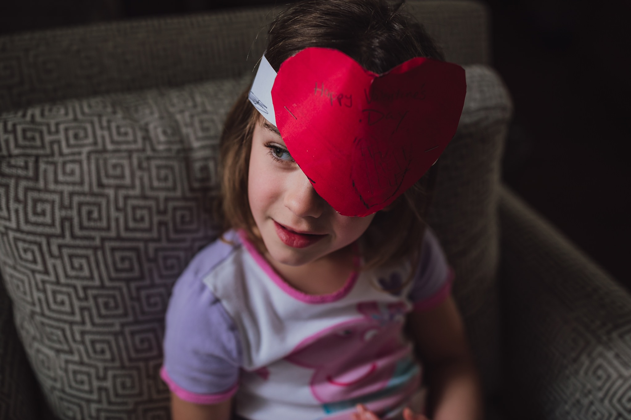 girl looks out window with Valentine's hat on | Whidbey Island family photographer