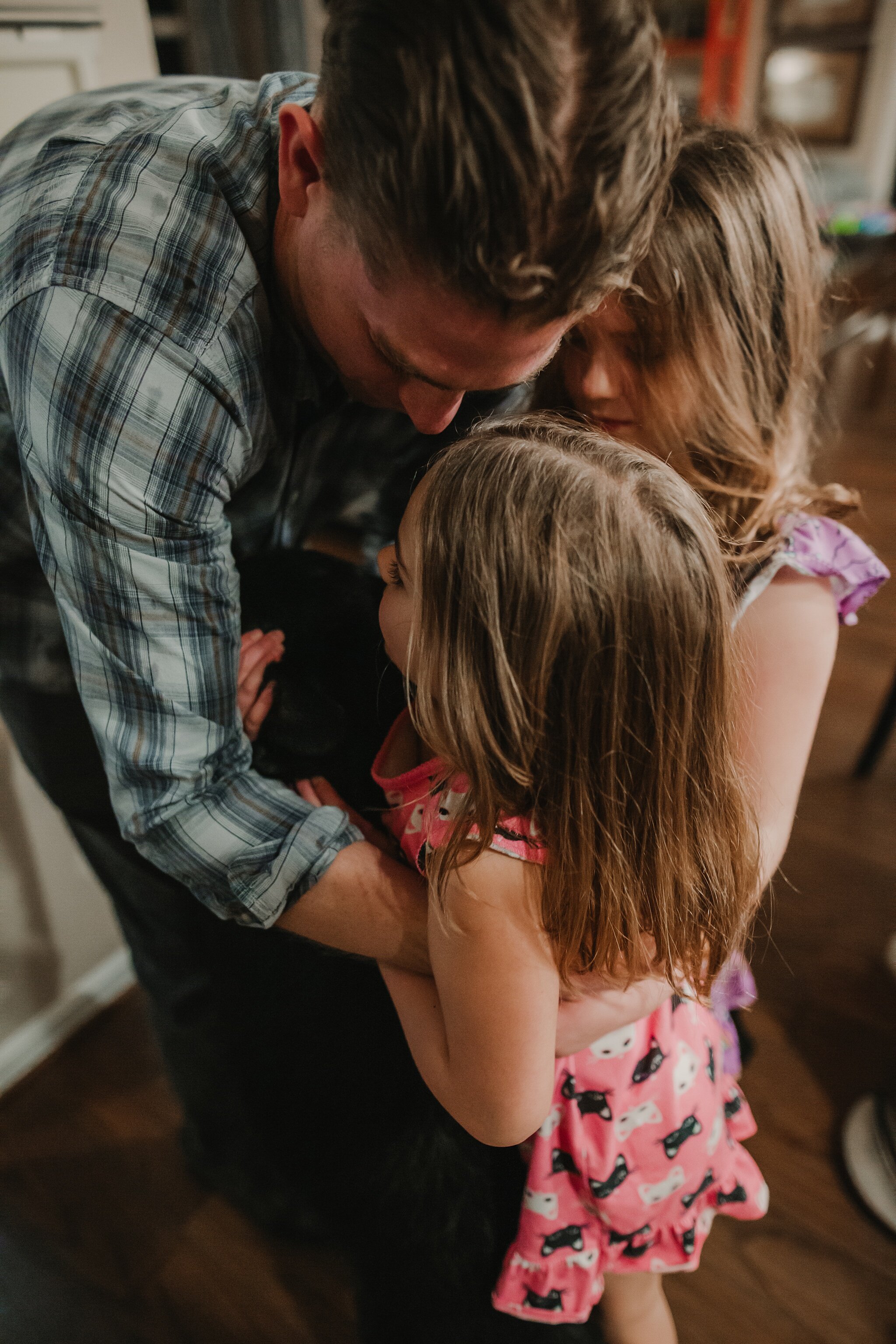 girls hug father as he walks in the door