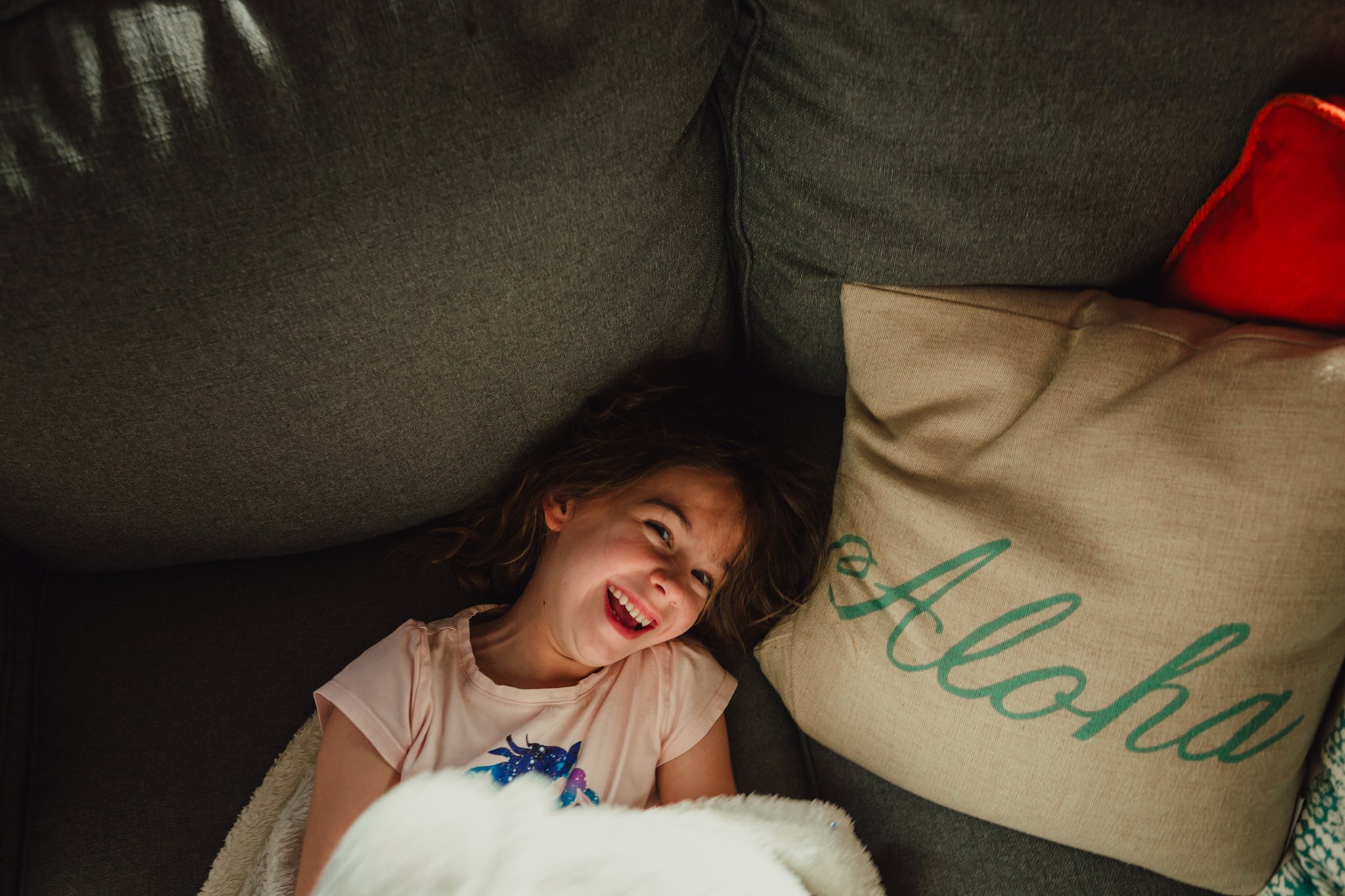 girl laughs on couch