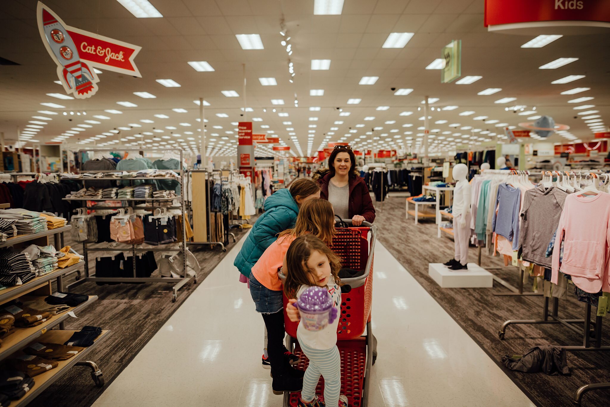 woman pushes cart of kids in Target