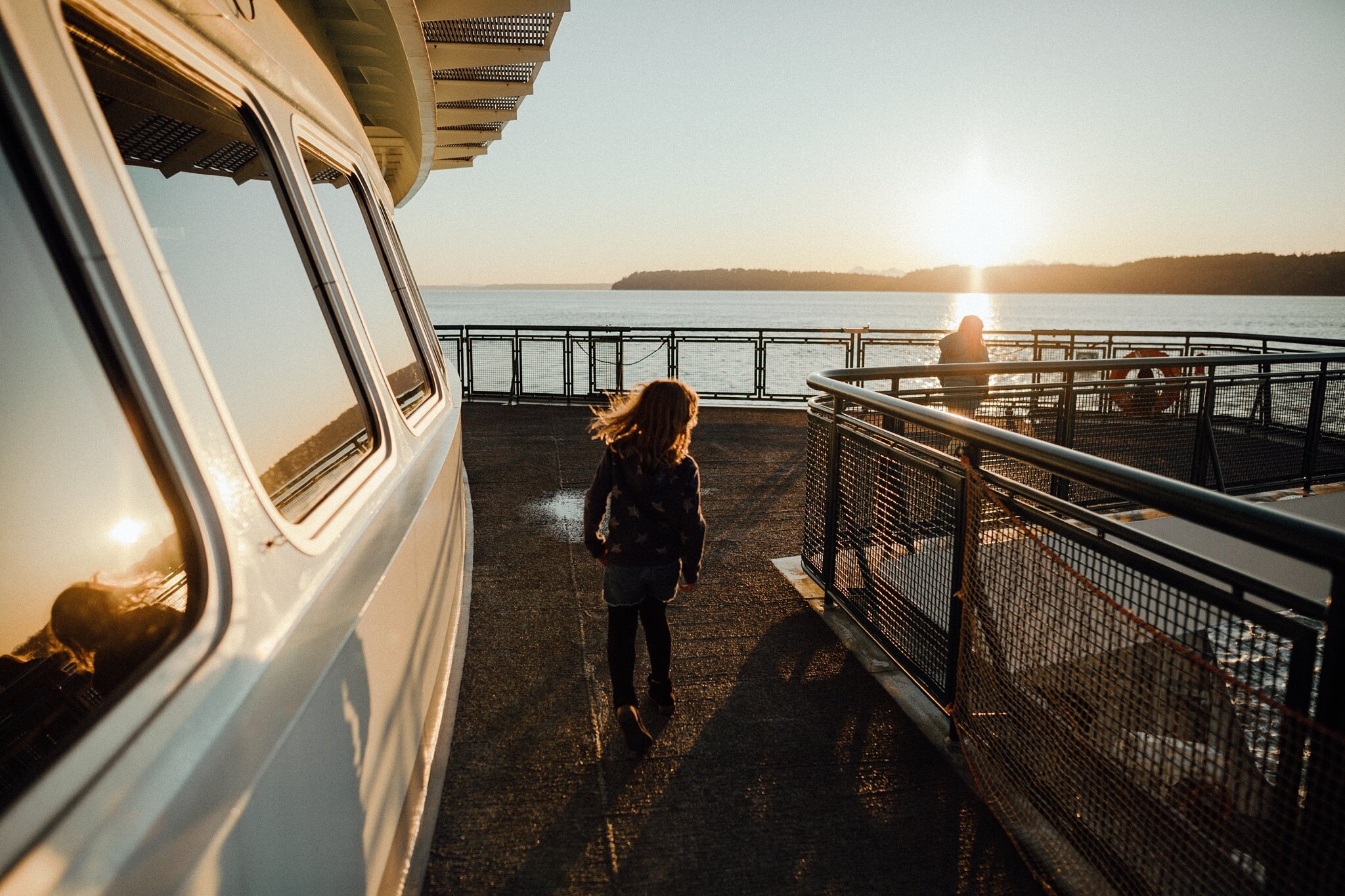 girls walk on bough of ferry in Washington state