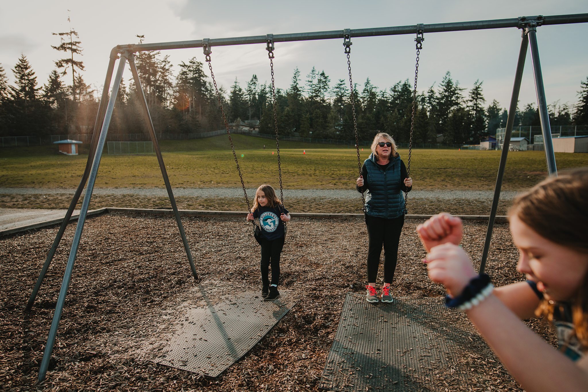 girls play on playground with aunt