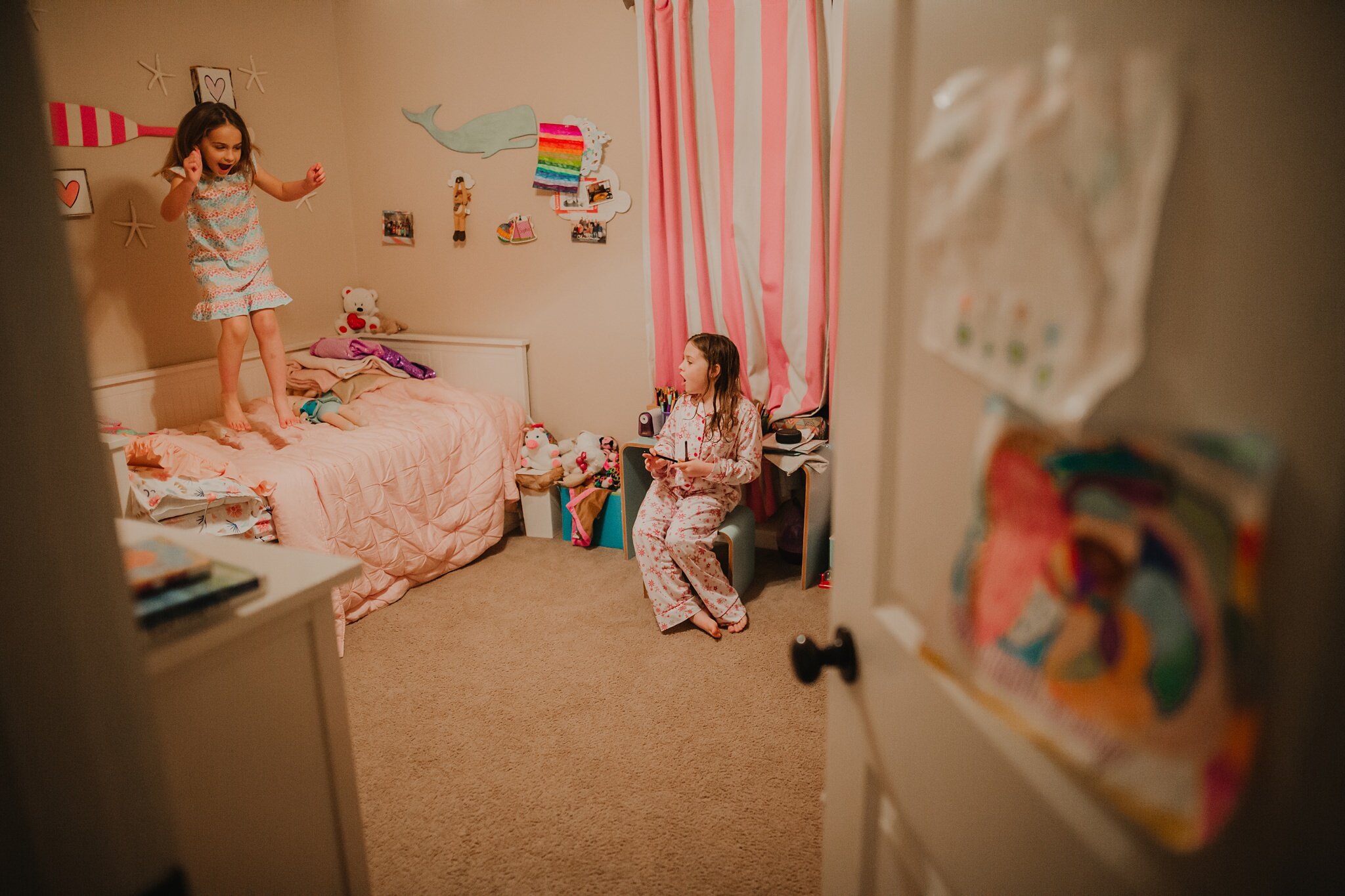 girls play in room and jump on bed