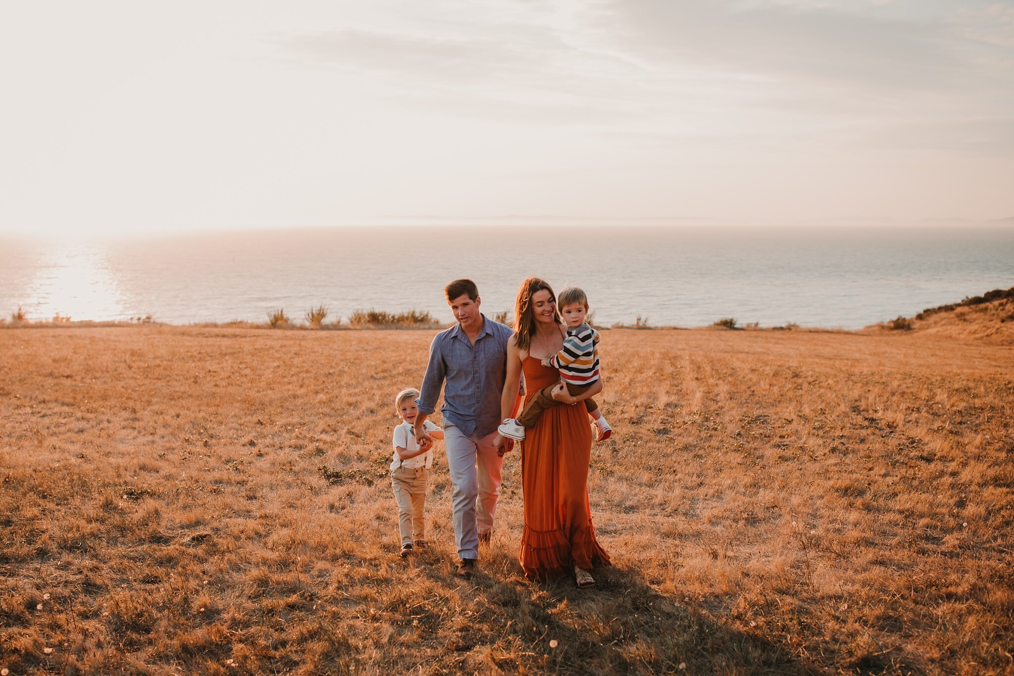 beautiful family walks across field at fort ebey state park