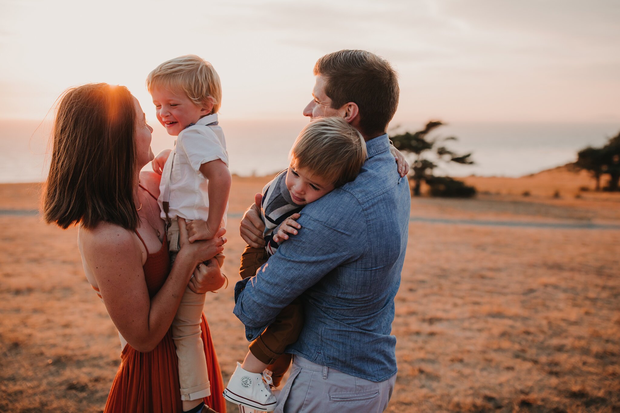 parents hold and snuggle boys during photo shoot on whidbey island
