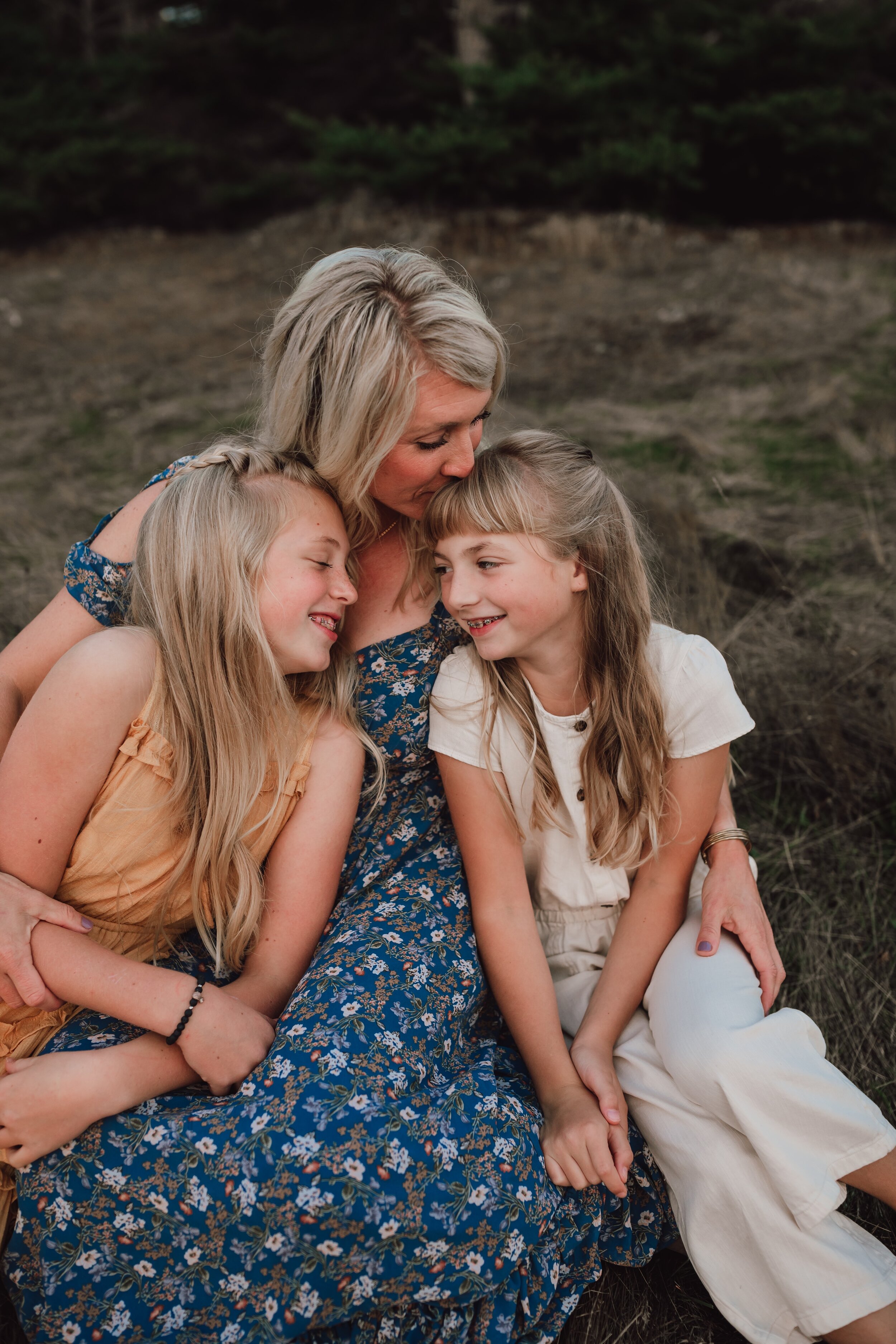 mother holds daughters during family photo session