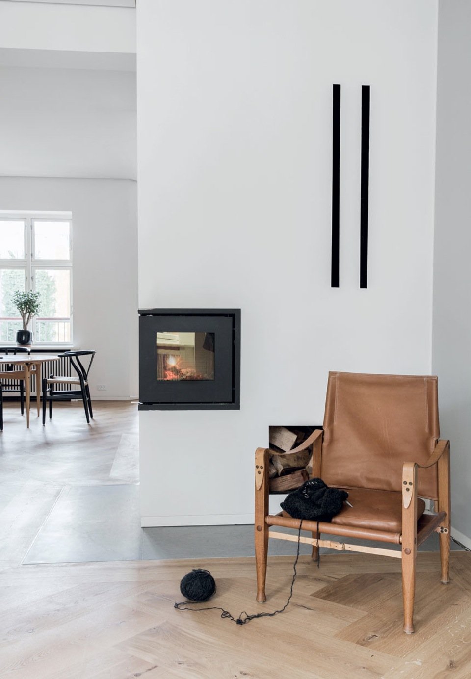 In a warm corner in front of the fireplace stands a Kaare Klint Safari Chair.